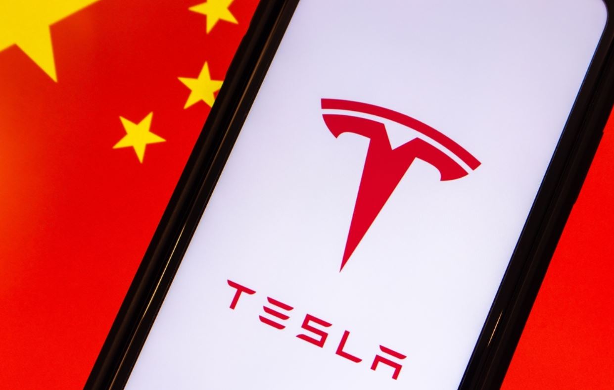 Tesla vu sur smartphone, sur fond de drapeau chinois.