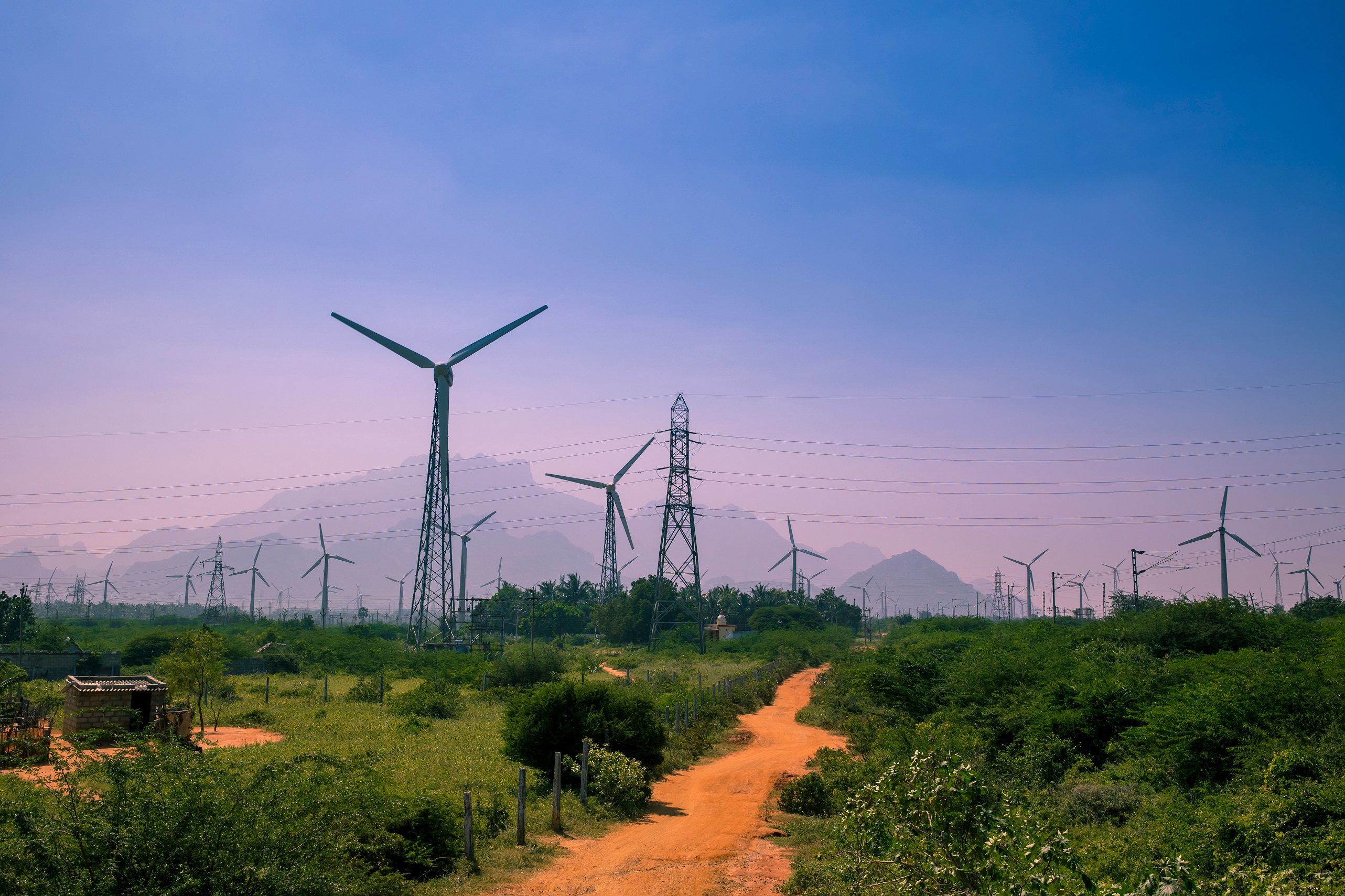 View of wind turbines farm in Nagercoil, South India. With a colorful sky and mountains as a background