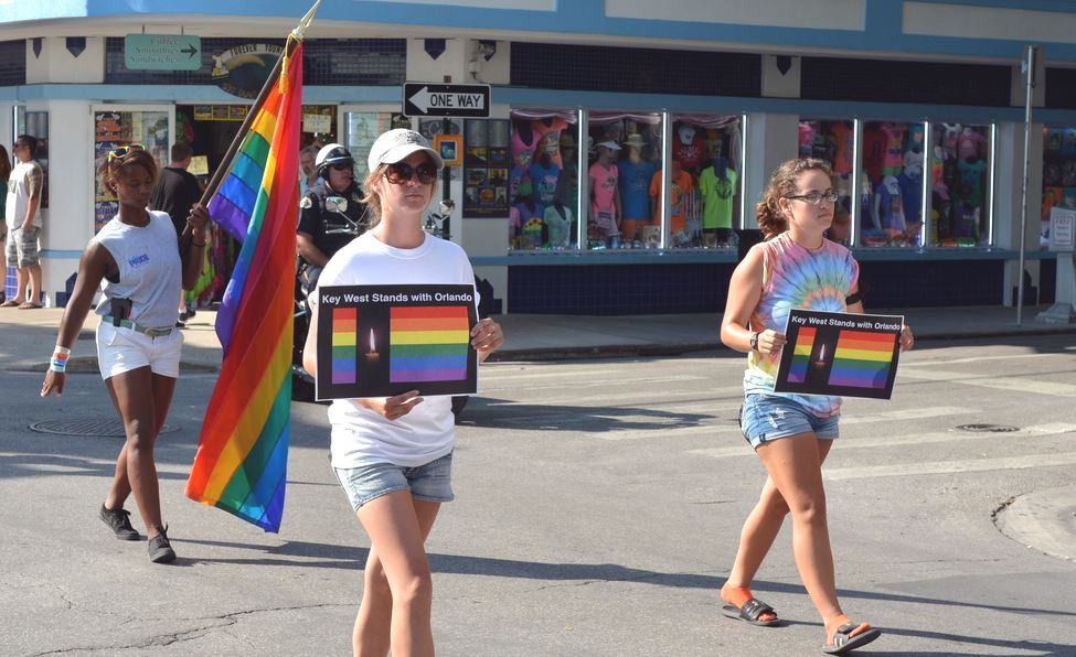 People marching in the Key West Gay Pride parade carry a memorial banner honoring those killed in the terror attack at the nightclub in Orlando, June 12, 2016. Credits: Chuk Wagner/Shutterstock