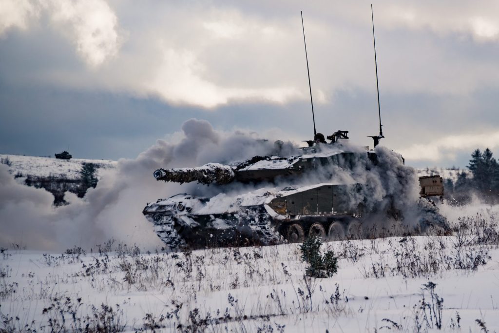 Un char Léopard des Forces armées canadiennes assaille les forces ennemies pendant l'exercice Common Ground au camp Petersville dans la zone d'entraînement de la base de soutien de la 5e division canadienne à Gagetown, 21 novembre 2018