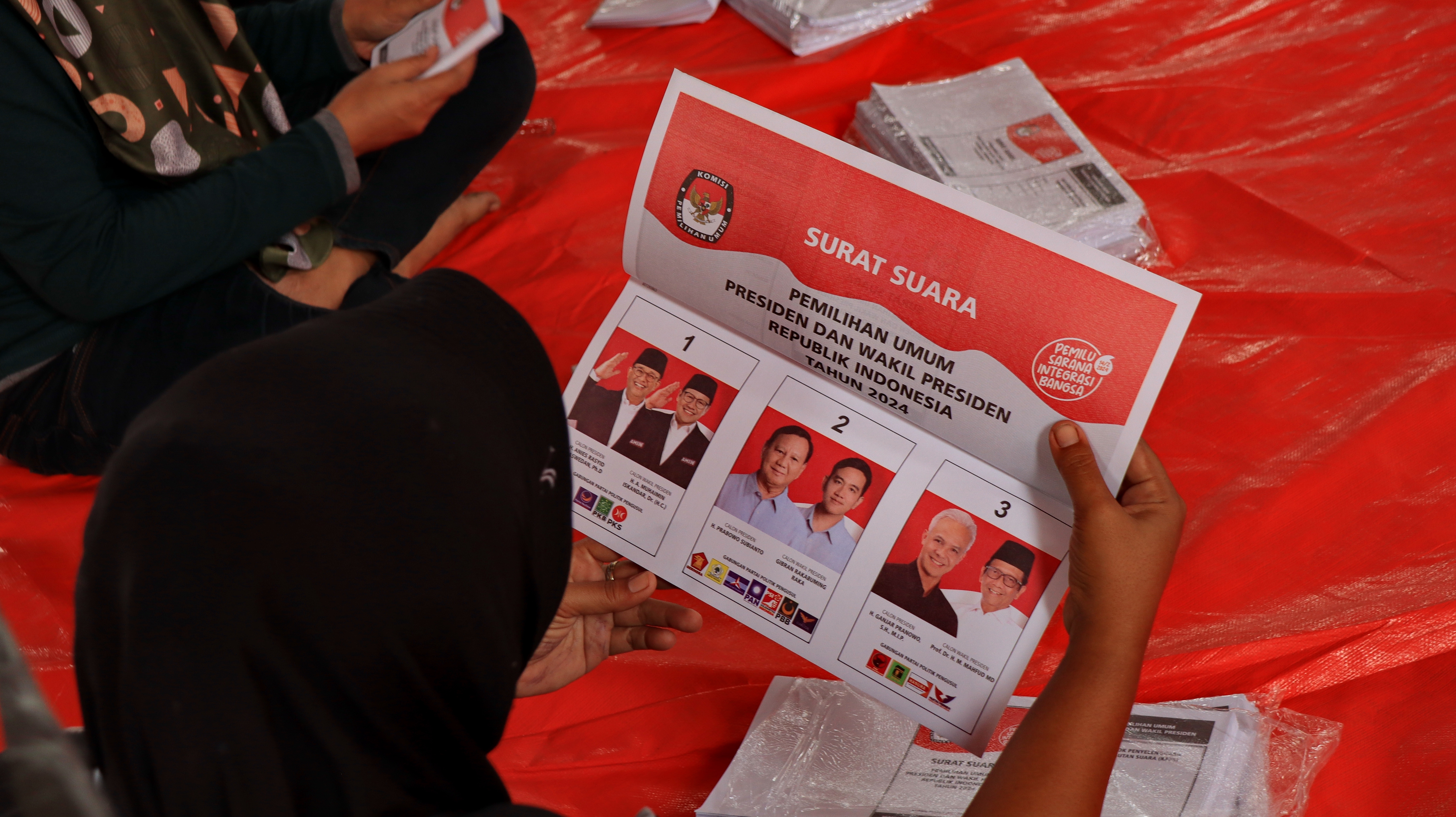 Freelance daily workers fold ballot papers for the 2024 Election in a logistics storage warehouse, Pekalongan Indonesia January 5 2024 © onyengradar/Shutterstock